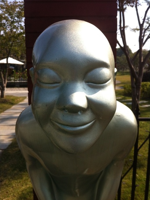 Large silver metal buddha smiling